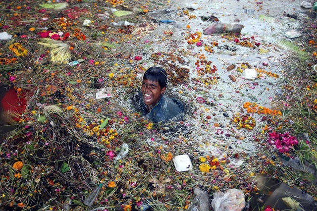 Cậu bé tìm tiền xu dưới nước ô nhiễm của sông Tawi trong lễ hội Navratri của người theo đạo Hindu ở Jammu, Ấn Độ.