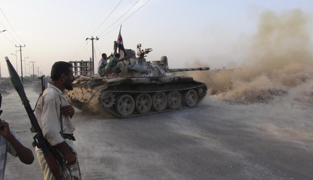 Các chiến binh ủng hộ chính phủ điều khiển xe tăng trong cuộc giao tranh với phiến quân Houthi ở Aden, Yemen.