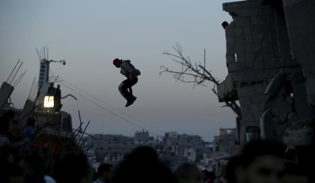 Một thanh niên người Palestine luyện tập nhảy Parkour trên những ngôi nhà đổ nát ở thành phố Gaza.