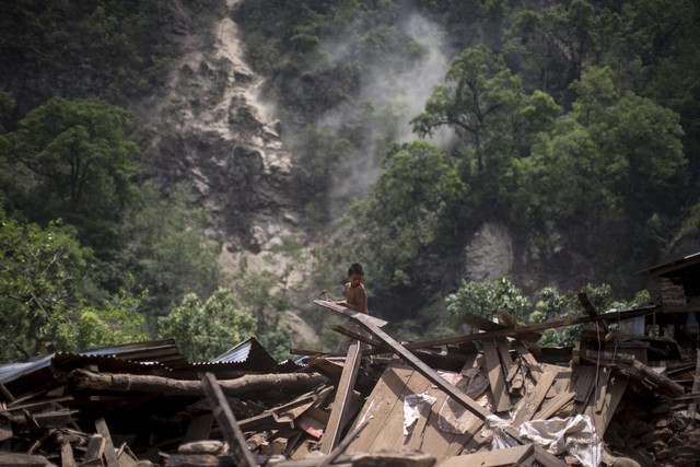 Cậu bé dỡ bỏ đống đổ nát của nhà mình sau trận lở đất do động đất tại ngôi làng Singati, Dolakha, Nepal.