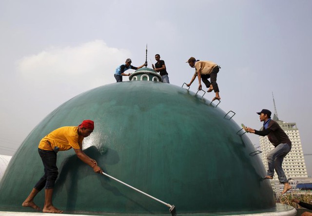 Các thanh niên lau mái vòm của một nhà thờ trước tháng lễ Ramadan của người Hồi giáo ở Jakarta, Indonesia.