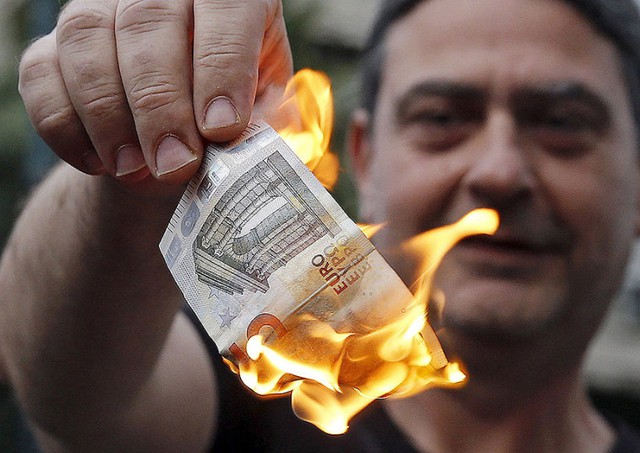 Người chống chính sách khắc khổ đốt một tờ tiền euro trong cuộc biểu tình bên ngoài văn phòng của Liên minh châu Âu ở Athens, Hi Lạp.