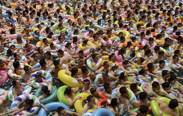 Đám đông chen chúc nhau dưới bể bơi để tránh bóng tại một khu nghỉ dưỡng ở thành phố Toại Ninh, Trung Quốc.