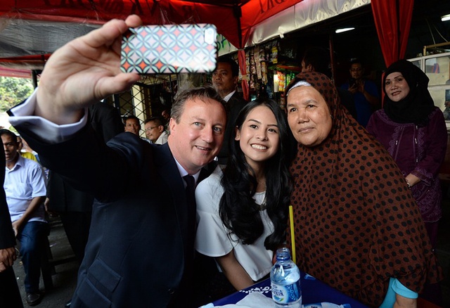 Thủ tướng Anh David Cameron chụp ảnh “tự sướng” với diễn viên kiêm ca sĩ Maudy Ayunda tại một khu chợ đường phố ở Jakarta, Indonesia.