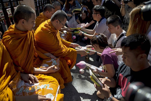 Thân nhân của các nạn nhân người Malaysia tỏ lòng tôn kính với các tu sĩ Phật giáo trong một buổi lễ tại đền Erawan ở Bangkok, Thái Lan.