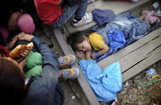 Em bé tị nạn người Syria ngủ ngay cạnh đường ray tàu hỏa tại Hi Lạp trong khi chờ vượt qua biên giới sang Macedonia.