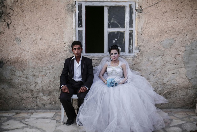 Một cặp đôi mới cưới chụp ảnh trước nhà họ tại thành phố Kobane, Syria.