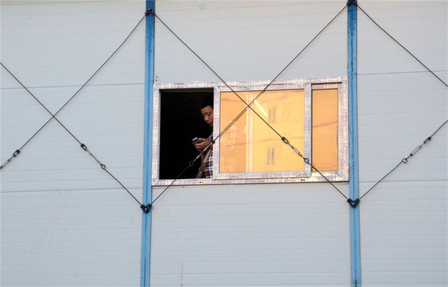 
Một người đàn ông không rời mắt khỏi chiếc điện thoại trong một căn nhà tạm xây dựng ở Bắc Kinh.
