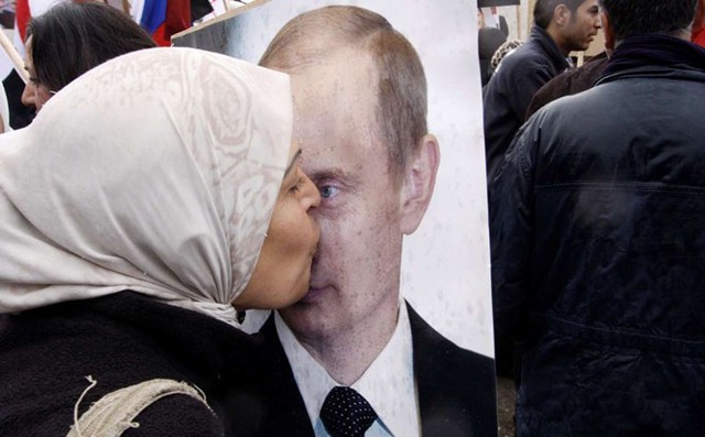 Một phụ nữ Syria hôn ảnh chân dung của Tổng thống Nga Putin trong cuộc tuần hành ủng hộ chính phủ ở thủ đô Damascus.