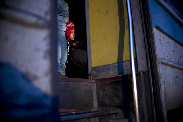 Một cô bé quan sát những người di cư và người tị nạn lên một chuyến tàu đến Serbia sau khi vượt qua biên giới Hy Lạp-Macedona.
