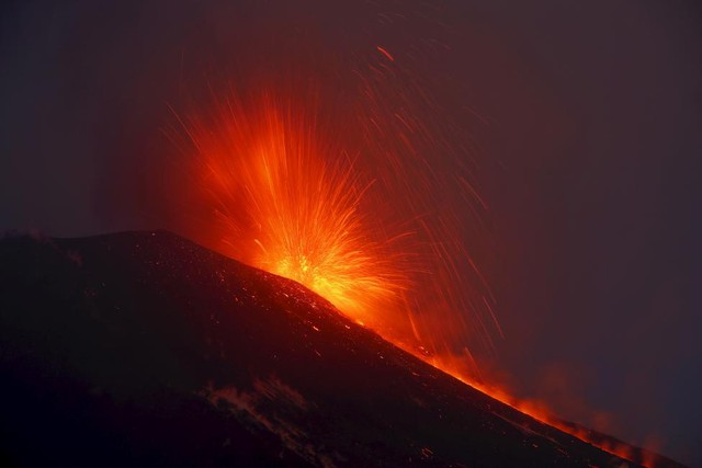 Cảnh tượng dung nham đỏ rực phun trào ra từ miệng núi lửa Etna trên đảo Sicily, Italia.