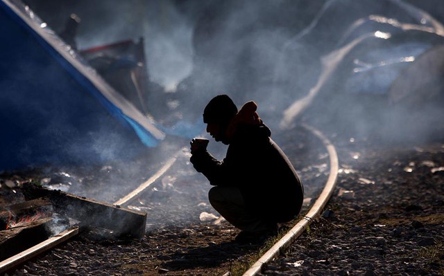 Một người di cư ngồi trên đường ray để chờ vượt qua biên giới Hy Lạp-Macedonia gần Idomeni, Hy Lạp.