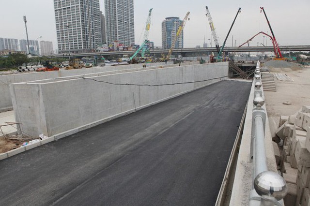 
Hai đường dẫn đang được đổ sỏi và một bên đã được trải nhựa. Theo lãnh đạo Ban quản lý dự án Thăng Long (chủ đầu tư), hầm chui Trung Hòa sẽ thông xe vào ngày 31/12, vượt tiến độ 6 tháng.
