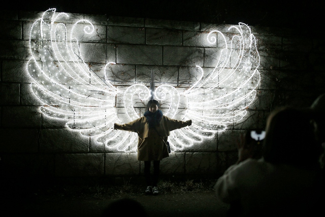 Thiếu nữ chụp ảnh trước một tác phẩm nghệ thuật sắp đặt bằng ánh sáng tại thành phố Seoul, Hàn Quốc.