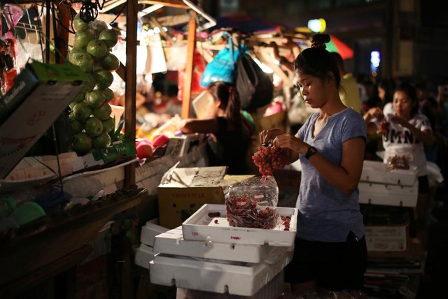 Người phụ nữ chuẩn bị nho để bán tại một khu chợ trái cây ở thành phố Manila, Philippines.