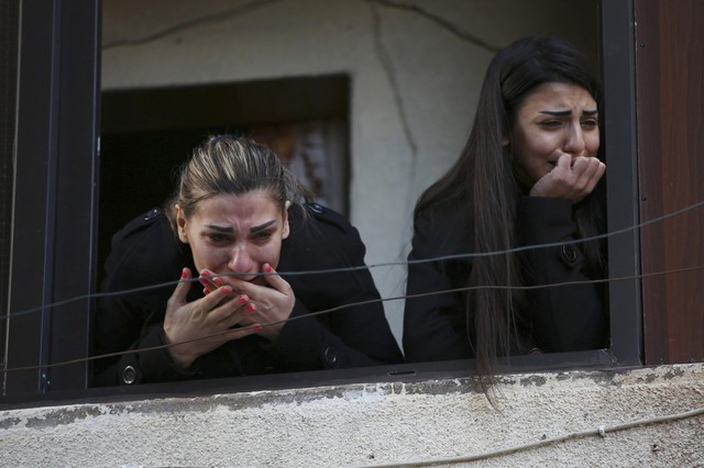 Hai phụ nữ bày tỏ sự tiếc thương khi chứng kiến đám tang của những nạn nhân thiệt mạng trong vụ đánh bom liều chết kép xảy ra tại một quán cà phê ở thành phố Tripoli, Li Băng.
