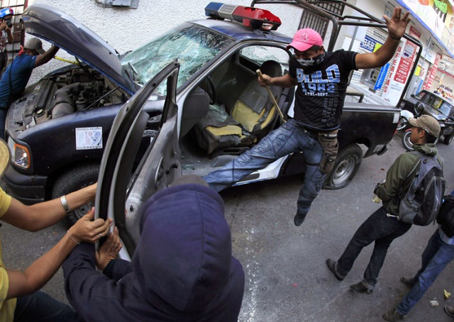 Người biểu tình phá xe của cảnh sát tại thành phố Chilpancingo, bang Guerrero, Mexico.