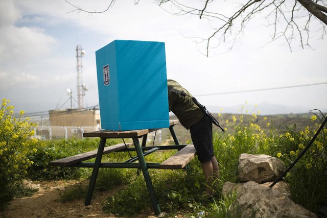 Một binh sĩ Israel bỏ biểu bầu quốc hội tại một hòm bỏ phiếu di động ở Bờ Tây.