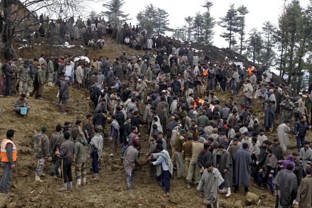 Cảnh sát và nhân viên cứu hộ tìm kiếm thi thể nạn nhân bị chôn vùi dưới bùn đất sau trận lở đất tại ngôi làng Laden ở Srinagar, Ấn Độ.