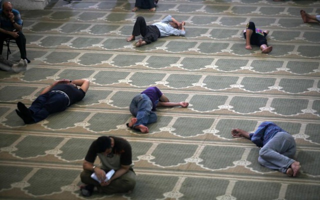 Người dân Palestine nằm nghỉ trong khi chờ bữa tối trong ngày đầu tiên của tháng lễ Ramadan ở thành phố Gaza.