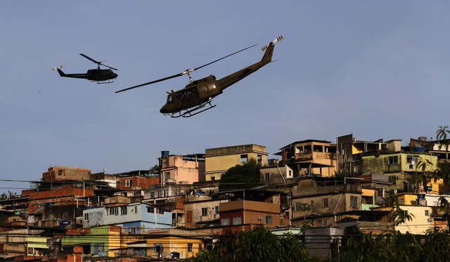Trực thăng cảnh sát bay tuần tra trên khu ổ chuột Mare ở Rio de Janeiro, Brazil.