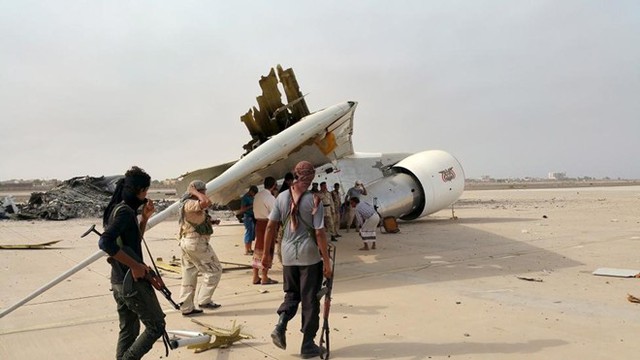 Các tay súng kiểm tra mảnh vỡ của chiếc Boeing 747 bị phá hủy ở sân bay quốc tế Aden, Yemen.