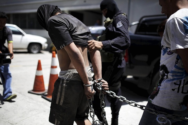 Các nghi phạm giết người bị cảnh sát dẫn giải lên xe tại thành phố San Salvador, El Salvador.