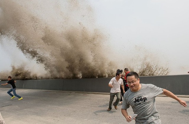 Du khách chạy khỏi sóng triều cường trên sông Tiền Đường ở tỉnh Chiết Giang, Trung Quốc.