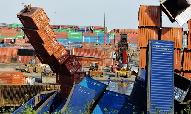 Công nhân đang dọn dẹp các thùng container bị hư hại sau vụ nổ tại Thiên Tân, Trung Quốc vào tháng trước.