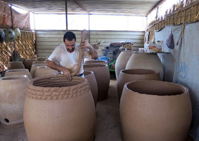 Công nhân làm những vại gốm tại xưởng ở thành phố Kadhimiya, Iraq.
