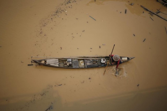 Ngư dân kiểm tra bẫy cá dưới sông Kahayan ở thành phố Palangkaraya, Indonesia.