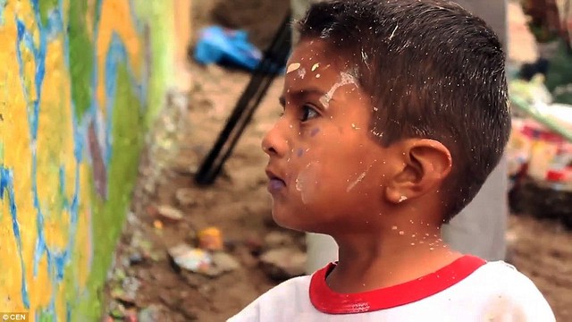 
Những đứa trẻ tại khu ổ chuột vui vẻ tham gia vào hoạt động vẽ tranh tường của các nhà hoạt động xã hội Peru nhằm lên án bức tường ô nhục này.
