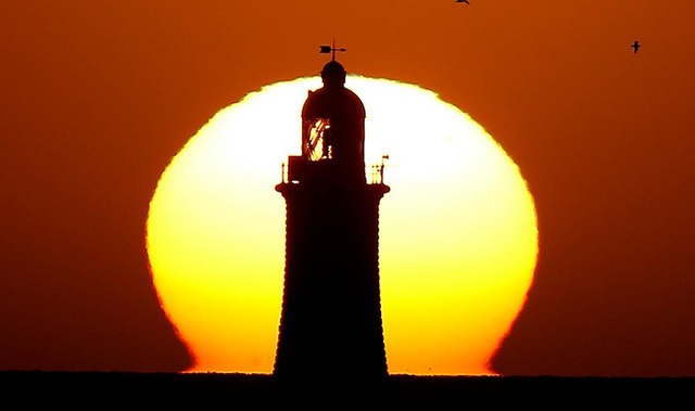 Cảnh mặt trời mọc huy hoàng sau ngọn hải đăng ở Tynemouth, Anh.