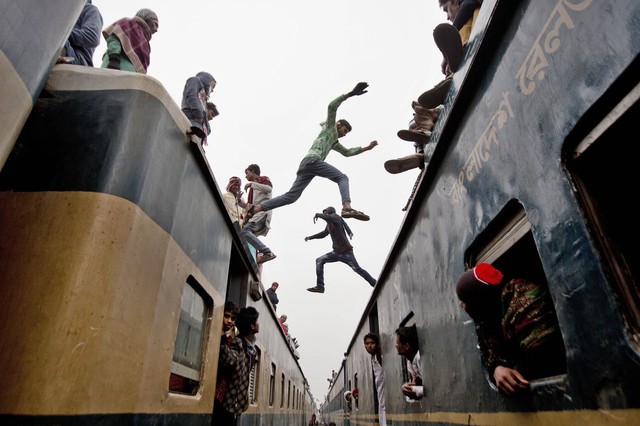 Các nam thanh niên nhảy qua nóc những toa tàu, khi hàng nghìn người Hồi giáo ở Bangladesh cố gắng trở về nhà sau khi tham dự 3 ngày lễ trên bờ sông Turag ở Tongi, thành phố Dhaka.