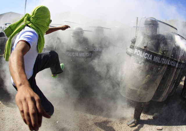 Người biểu tình đạp khiên của cánh sát bán quân sự trong cuộc đụng độ ở Iguala, Mexico.