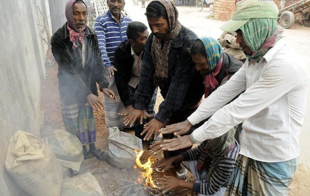 Người dân sưởi ẩm quanh đống lửa trong một buổi sáng lạnh ở Dhaka, Bangladesh.