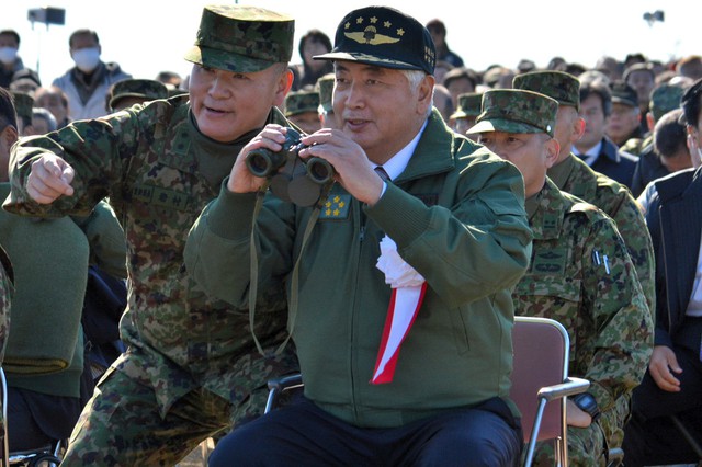 Thiếu tướng Kimihito Iwamura, Tư lệnh của Lữ đoàn dù số 1 của quân đội Nhật Bản, hướng dẫn Bộ trưởng Quốc phòng Nhật Bản Gen Nakatani quan sát cuộc tập trận bằng ống nhòm.