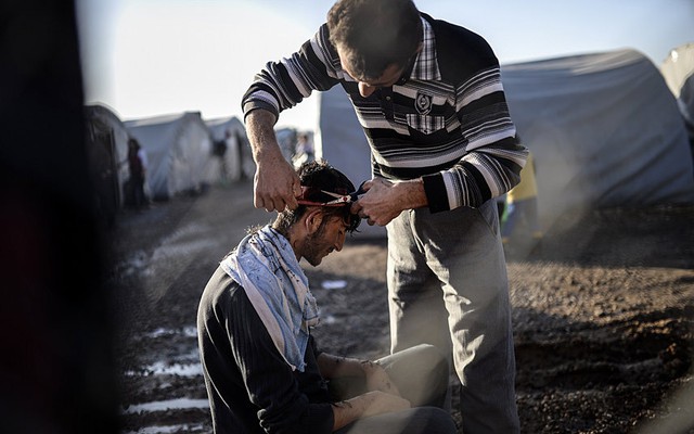 Một người tị nạn Syria cắt tóc bên ngoài trại tị nạn Rojava ở Sanliurfa, Thổ Nhĩ Kỳ.
