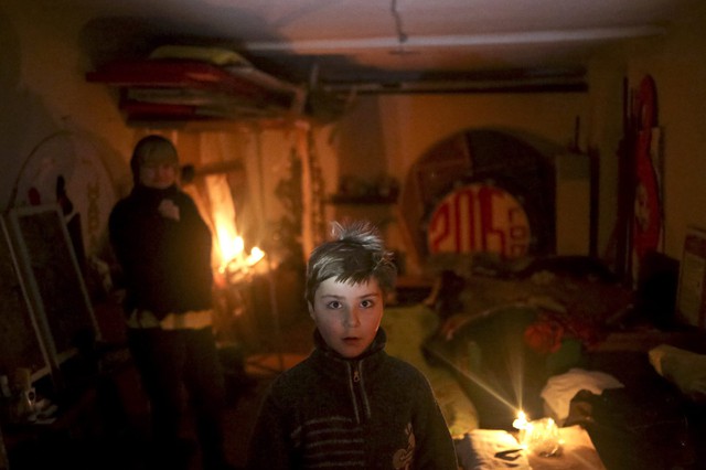 Trẻ em và người gia trú dưới hầm tránh bom tạm tại thị trấn Debaltseve, miền đông Ukraine.