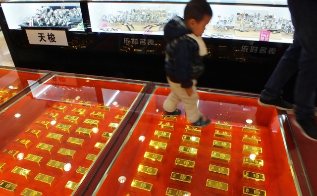 Em bé bước dọc một lối đi được xây bằng vàng ròng trong một trung tâm thương mại ở thành phố Nghi Xương, Trung Quốc.