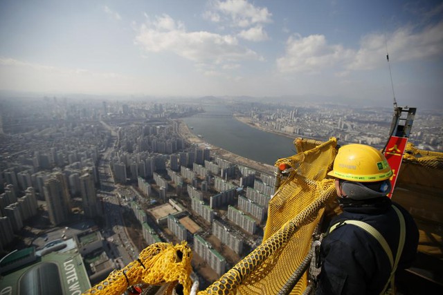 Công nhân nhìn từ tầng 99 của tòa tháp Lotte World Tower hiện đang được xây dựng ở Seoul, Hàn Quốc.