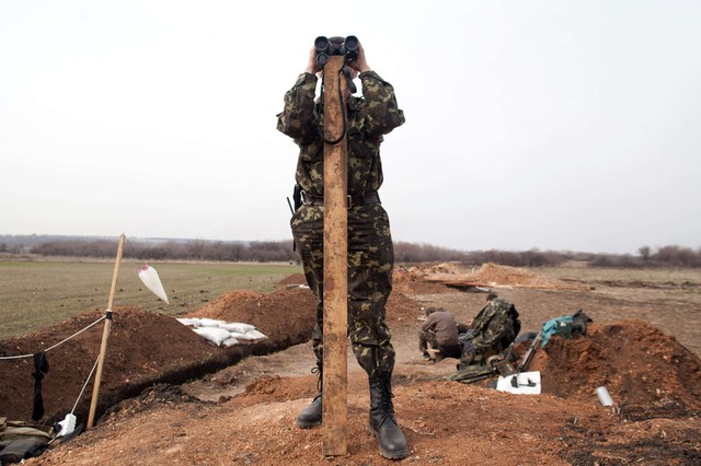 Binh sĩ Ukraine quan sát qua ống nhòm khi đứng gác tại một điểm chốt gần thị trấn Lysychansk.