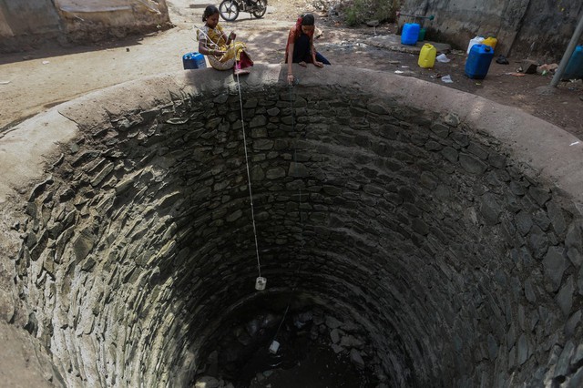 Những người phụ nữ lấy nước dưới giếng gần như khô cạn tại một ngôi làng ở Mumbai, Ấn Độ.