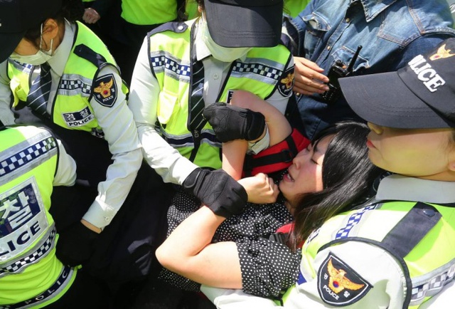 Cảnh sát bắt giữ một nữ sinh viên biểu tình chống chính phủ ở thủ đô Seoul, Hàn Quốc.