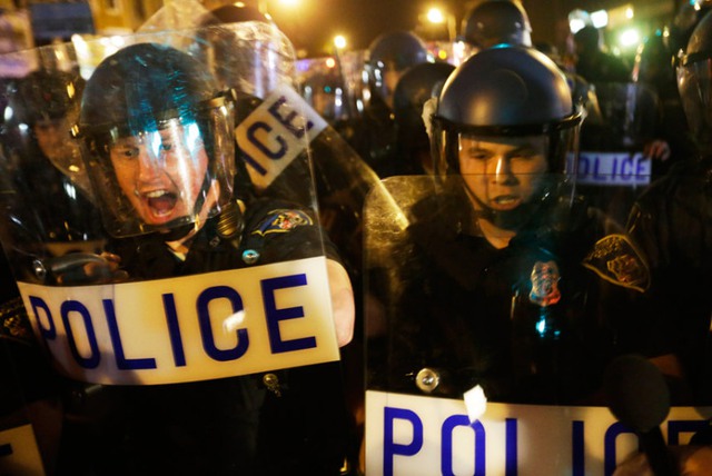 Cảnh sát chống bạo động ngăn chặn những người biểu tình tập trung trên phố ở Baltimore, Mỹ.