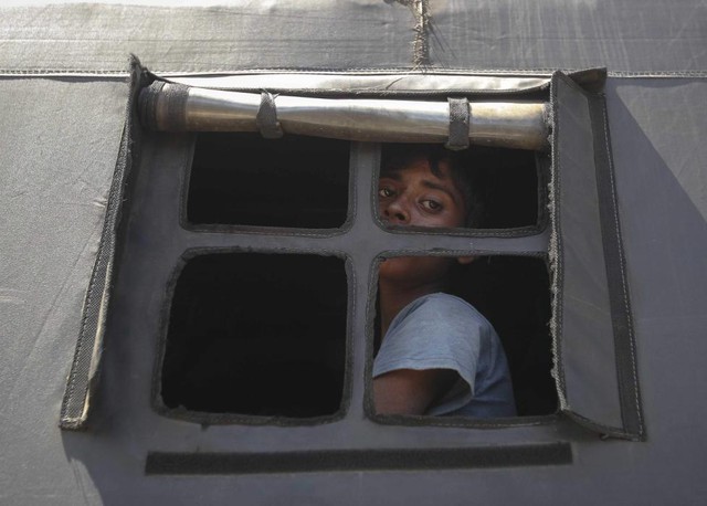 Một người nhập cư Rohingya nhìn ra ngoài cửa sổ xe cảnh sát khi được chuyển tới một trại tị nạn ở tỉnh Aceh, Indonesia.