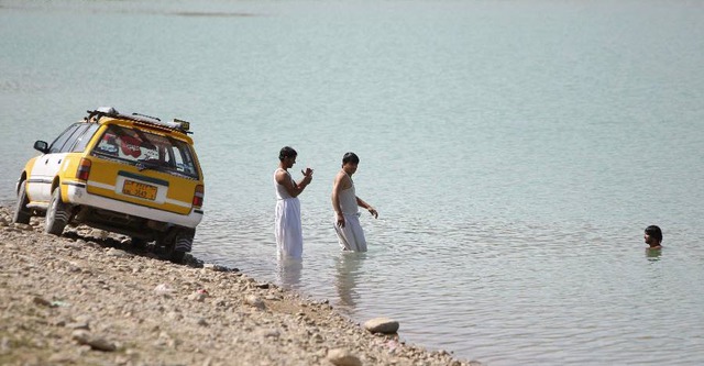 Người dân tắm mát dưới hồ Qargha trong một ngày nắng nóng ở Kabul, Afghanistan.