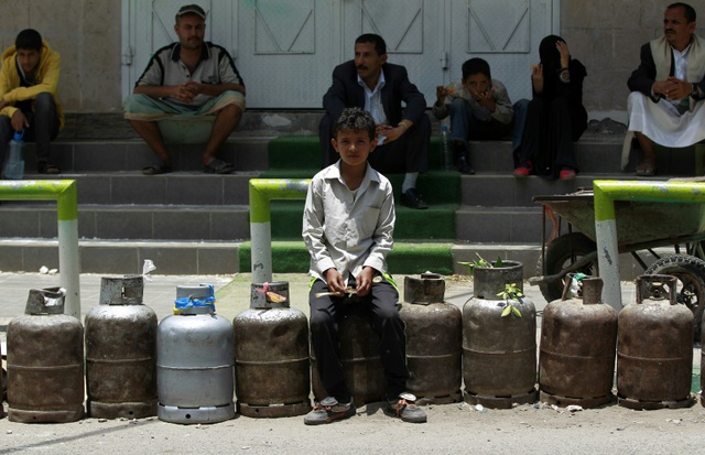 Người dân ngồi chờ bơm ga tại một trạm xăng trong bối cảnh thiếu hụt nhiên liệu gia tăng tại thủ đô Sanaa, Yemen.