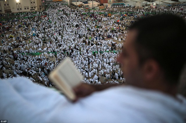 
Một tín đồ tranh thủ ngả lưng đọc kinh Koran. Ảnh: AP
