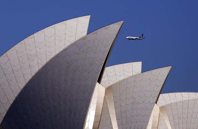 Chiếc máy bay Airbus A380 của hãng hàng không Singapore Airlines bay qua nhà hát Opera ở Sydney, Australia.